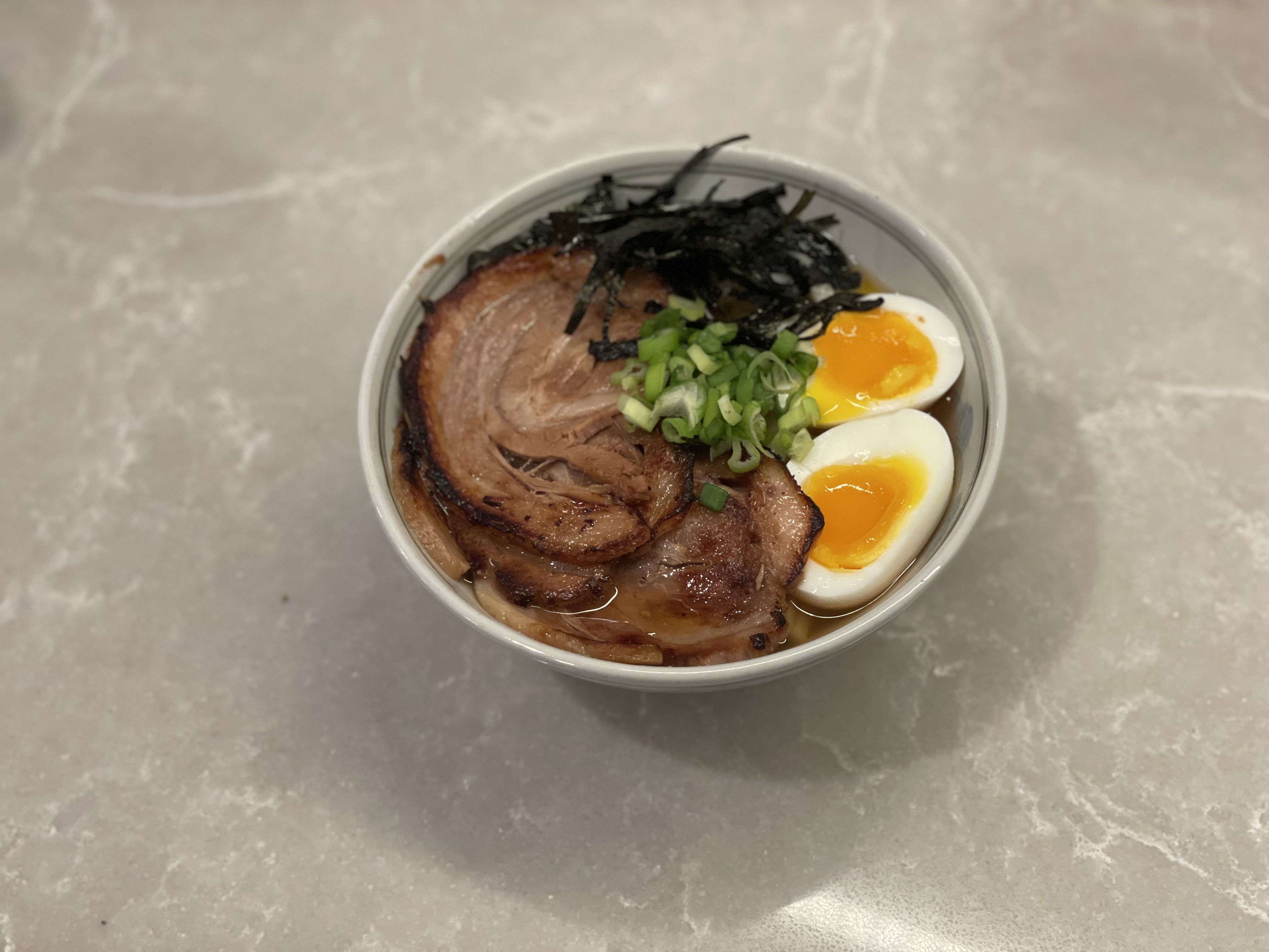 Ramen bowl with chashu pork, soft-boiled egg, nori, and scallions