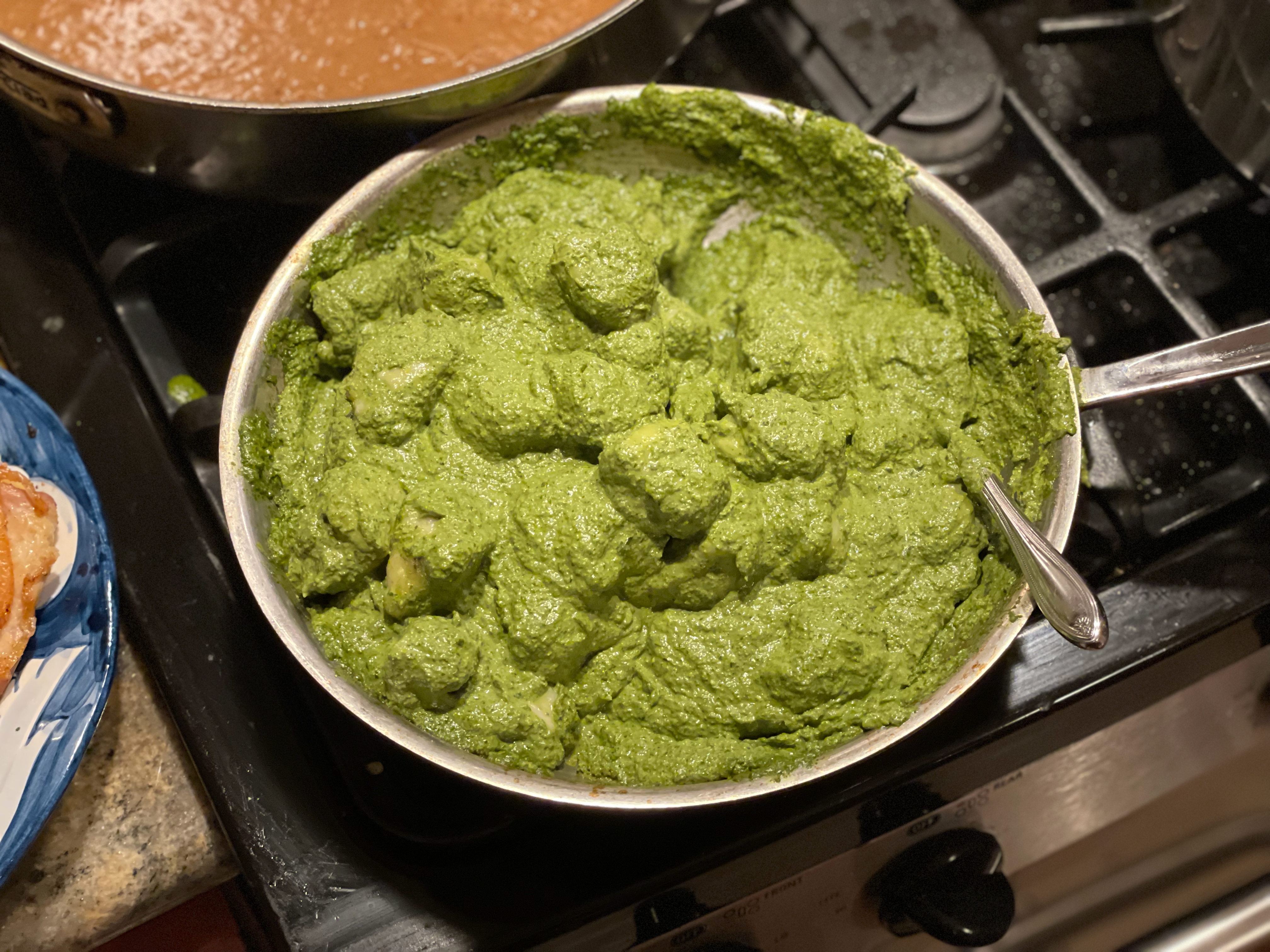 Bright green herb sauce cooking in a stainless steel pan on the stovetop