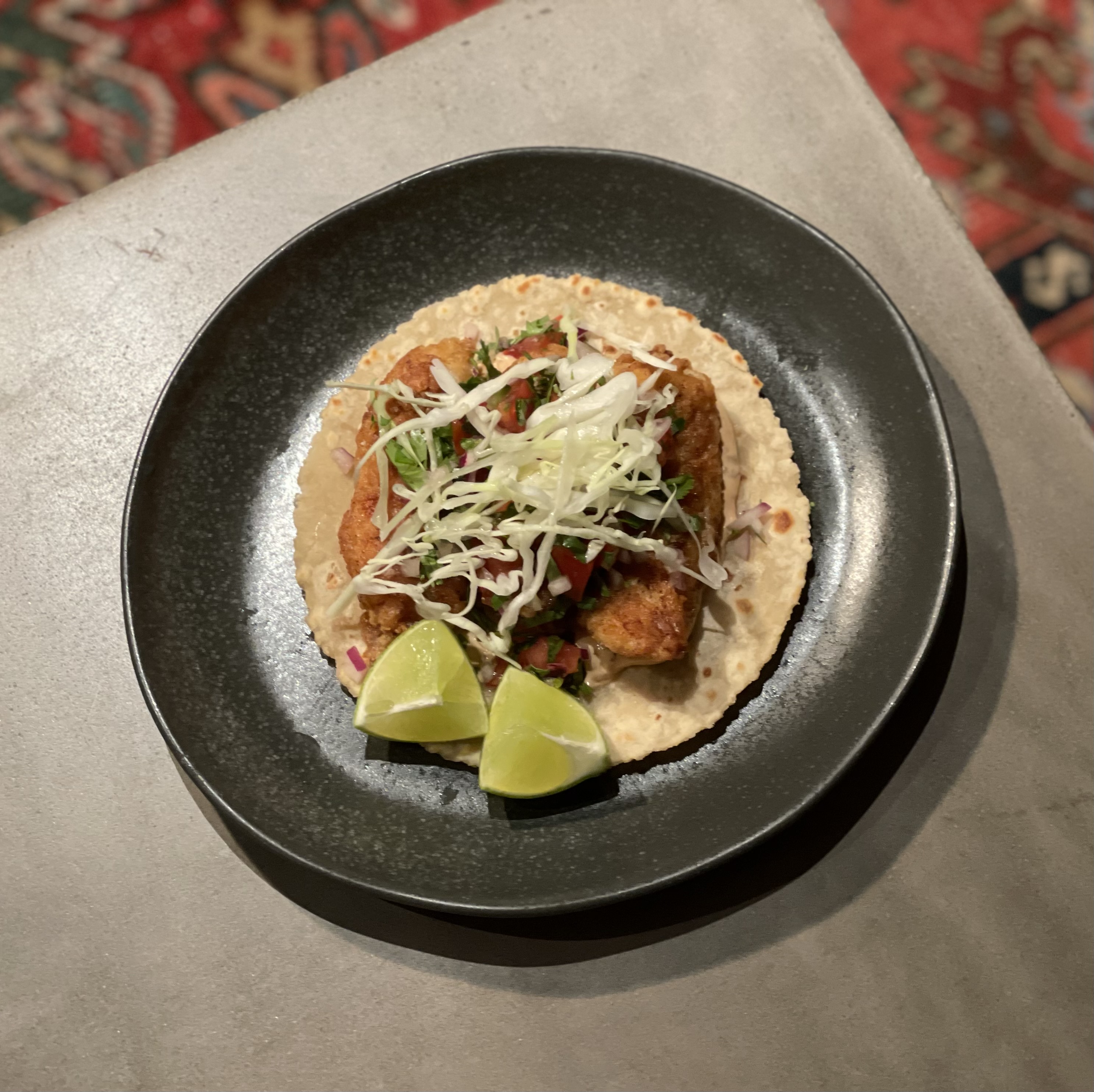 Soft tortilla with meat, shredded vegetables, and lime