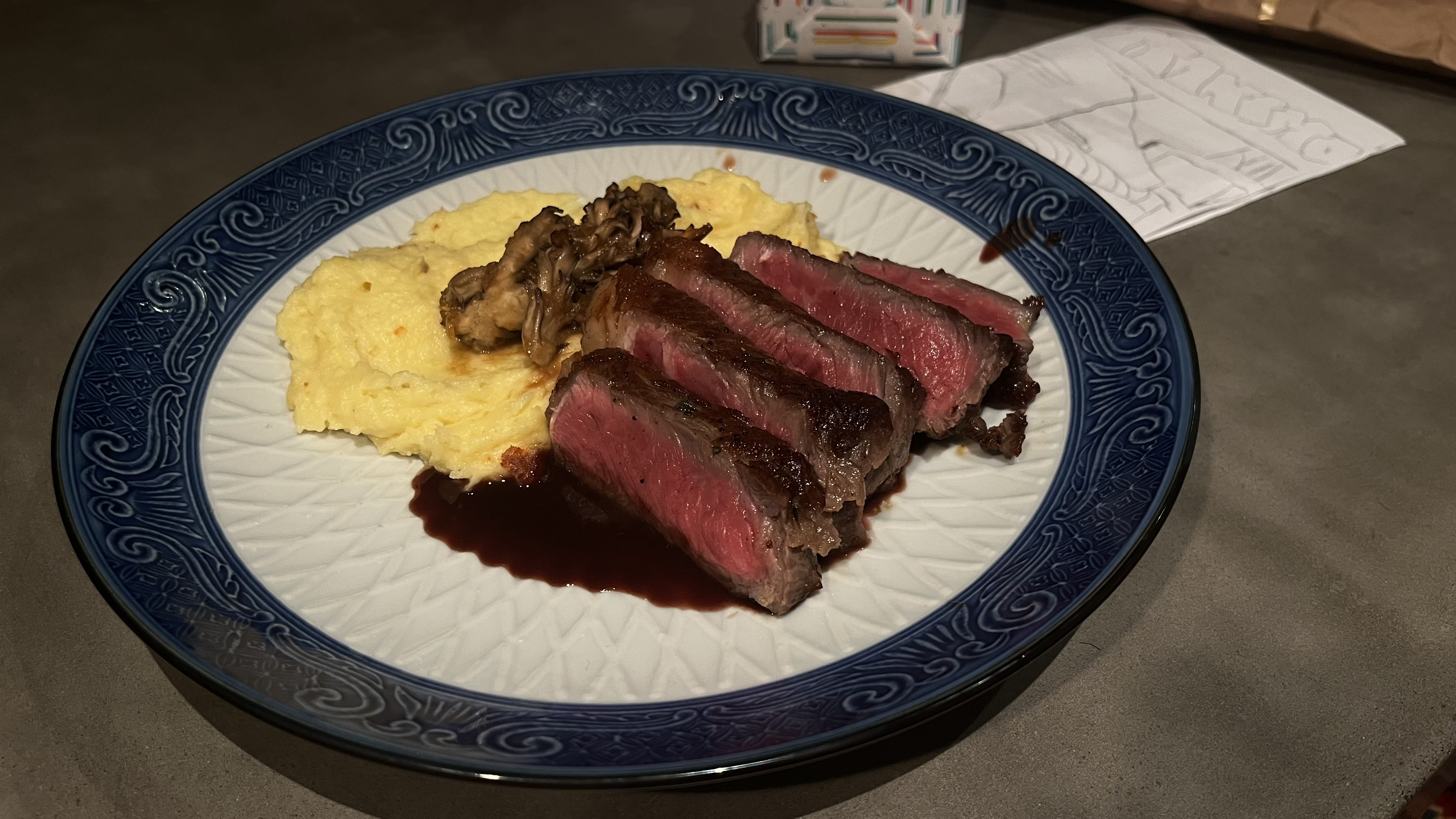 Seared steak with creamy polenta, sautéed mushrooms, and red wine reduction